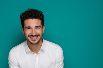 Obraz premium Friendly Young Man Smiling on Teal Background. 