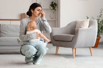 Obraz premium Tired mother suffering from postnatal depression with her baby at home