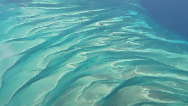 4k aerial video footage flying across turquoise water surface and a small atolls in The Bahamas, located in the Caribbean Sea in Atlantic Ocean.
