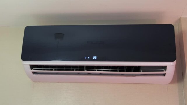 air conditioner opening vent at startup close-up, louver moving as unit turns on and begins airflow, home climate control device starting operation for cooling and indoor comfort