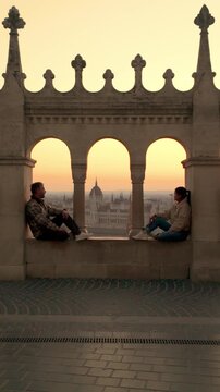 Relaxing moments as visitors enjoy breathtaking sunset views from the iconic Fishermans Bastion in Budapest. This historic location offers a picturesque backdrop for memorable experiences.