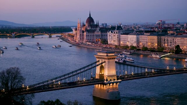 Experience the enchanting view of Budapest at sunset as the Chain Bridge lights up over the River Danube. This captivating moment showcases the beauty of Hungary, perfect for travel inspiration.