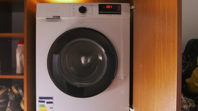 front load washing machine in high speed spin cycle, drum rotating rapidly to remove water from clothes, household appliance drying laundry during final stage of washing process
