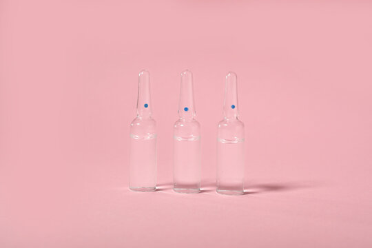 Glass ampules on pink background