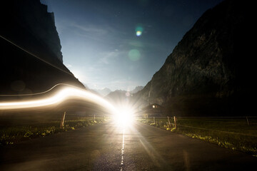 Long exposure night landscape with dynamic car light trails and mountain silhouettes in Lauterbrunnen valley, Switzerland © Mariusz