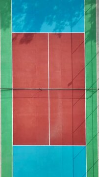 Aerial view of colorful tennis court with geometric lines