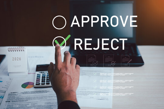 Business approval and rejection decision concept with hand selecting approve option on virtual interface, laptop and documents on desk.