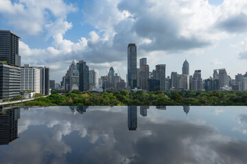 Fototapeta premium A panoramic view of Bangkok, Thailand, showing tall buildings surrounding Lumpini Park, reflecting Bangkok's green city image. Taken at Dusit Central Park, a favorite landmark for tourists and travele