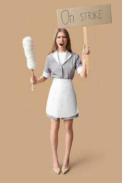 Protesting female chambermaid holding pp-duster and placard with text ON STRIKE against beige background