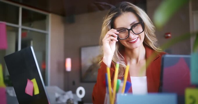 Smiling Businesswoman Working at Desk with Laptop