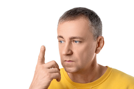 Mature man with contact lens on white background