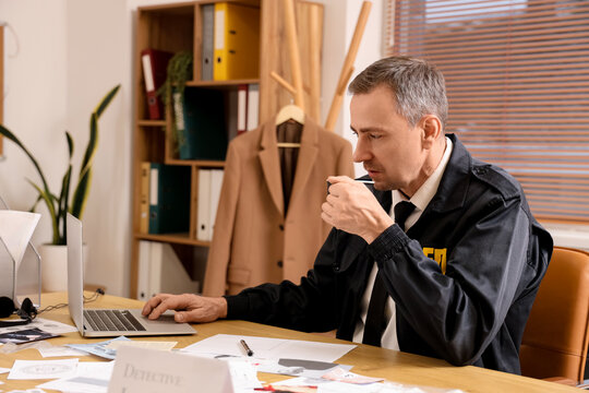 Mature FBI agent with coffee cup working at table in office