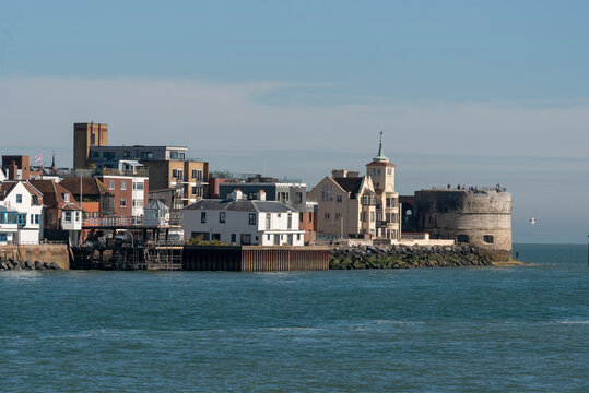 Old Portsmouth England UK. 25.04.2026. A scenic view of a historic seaside town featuring a prominent round tower, traditional houses, and contemporary architecture along the waterfront