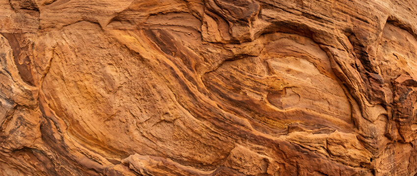 Close-up of reddish-brown sandstone with distinct stratification and intricate textural patterns