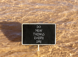 Naklejka premium Do new things every day words symbol. Concept words Do new things every day on beautiful black blackboard. Beautiful sea water background. Business do new things every day concept. Copy space.