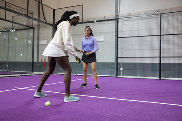 Obraz premium Left player bending and tossing ball, right player swinging racket, both practicing tennis drills