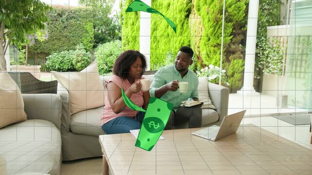 Couple reviewing laptop, papers, tapping phone causing money orbiting, reaching mugs, budgeting