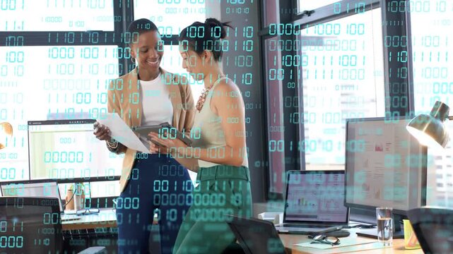 Right woman pointing tablet while left woman tracing paper, binary overlay guiding tech discussion