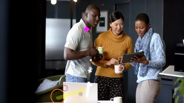 Three teammates leaning around tablet, right woman tapping and causing graphics for business review