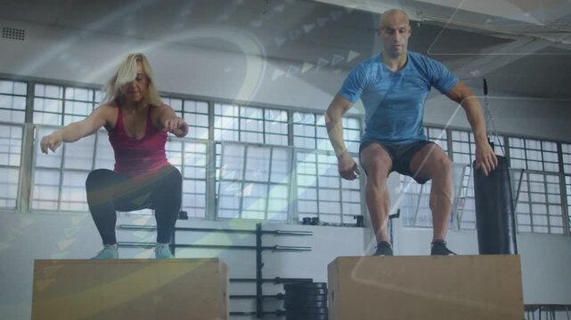 Two fitness partners beside plyo boxes, swinging arms and starting explosive box jumps for training