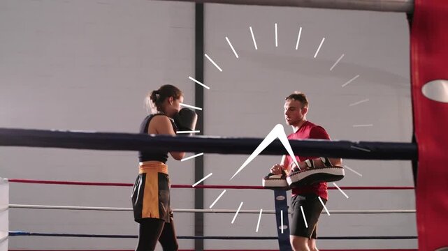 Coach holding pads cueing boxer throwing jabs and kicking for timed boxing rounds, timer advancing
