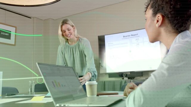 Presenter tapping tablet and reviewing quarter report, green overlay highlighting laptop charts
