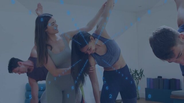 Instructor placing hand on student ribcage and raising arm guiding lateral stretch on mats for yoga