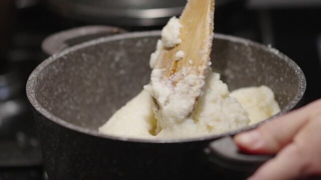 Cooking ghomi, a popular dish from the Samegrelo region made with coarse white corn flour