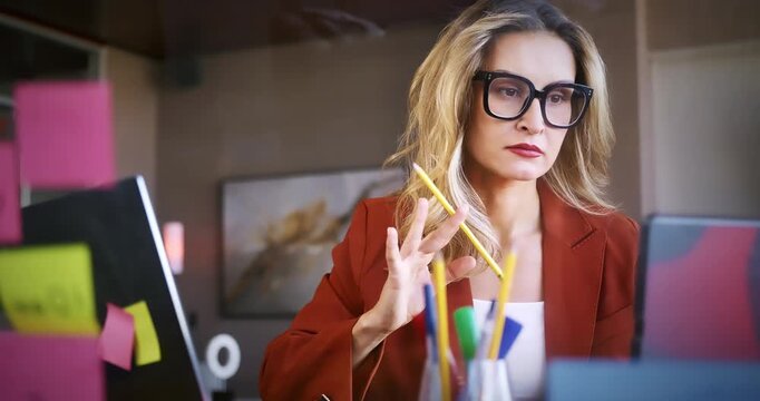 Focused Woman Working at Desk with Sticky Notes