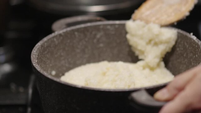 Cooking ghomi, a popular dish from the Samegrelo region made with coarse white corn flour