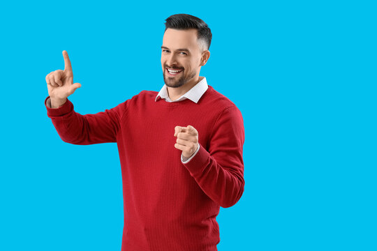 Handsome man showing loser gesture on blue background