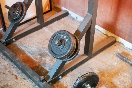 Weight plates and rack in a home gym setting, ready for a workout
