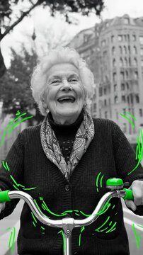 Senior woman riding bicycle and laughing in city. Happy grandmother enjoying urban bike ride concept. Active retired lifestyle with joyful emotion and movement. 160. Vertical video
