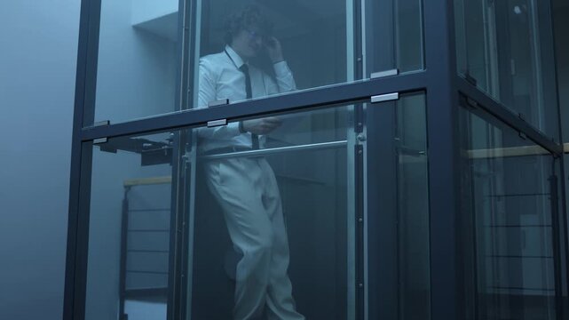 Dedicated businessman continues working in dark office after lights go out focused on documents staying productive until closing time showing commitment discipline and late night effort