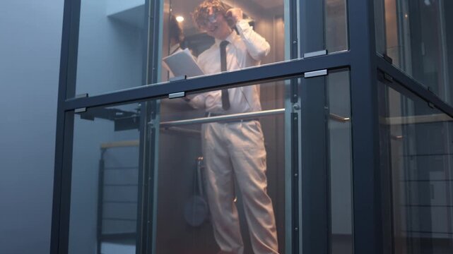 Tired office worker stretches and adjusts hair in quiet workplace after long day feeling exhausted but staying focused and professional until the very end of working hours