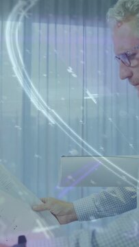 Vertical video: Designer reaching for plan, studying, tracing while blue waves animating over plan