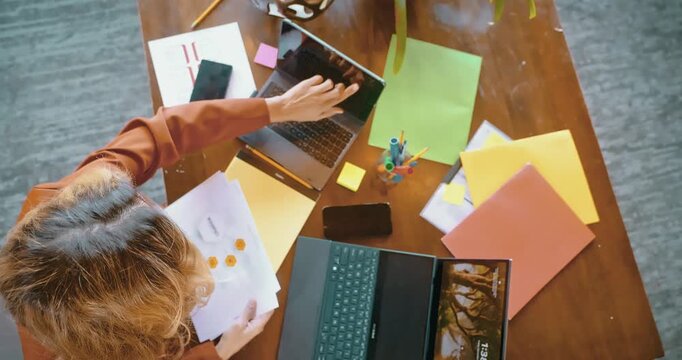 Overhead View of Woman Working with Laptop and Documents