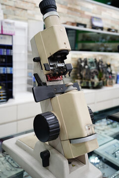 Vintage lensmeter device for measuring eyeglass lens power, professional optical equipment in optician shop or ophthalmology clinic.
