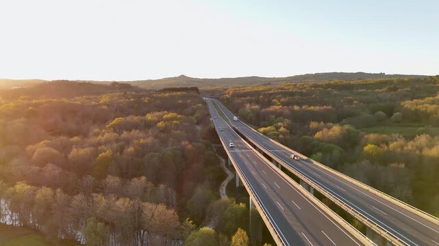 Allariz, Spain - 01 April 2026: Aerial view of Viaducto Arnoia bridge spanning a lush green valley with rolling hills at sunset.