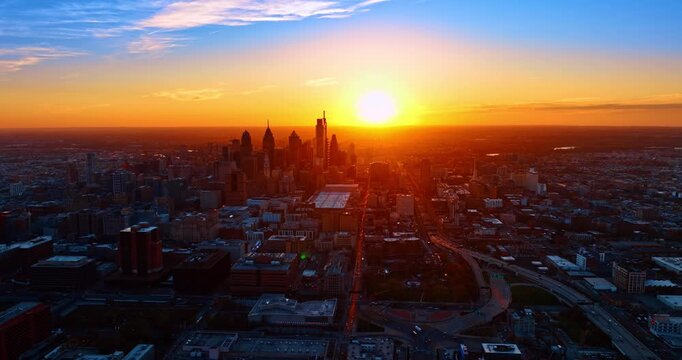 Heading to the downtown of Philadelphia, Pennsylvania, USA at sundown. Numerous cars move by the roads of the city at golden hour.