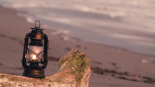 夕暮れの砂浜に置かれたアンティークなハリケーンランタン
