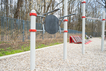 Abs trainer stands in a park with trees around during daytime on a clear day in early spring © Elena