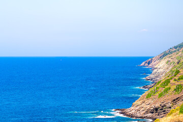 Fototapeta premium Karavostamo, Ikaria Greek fishing village with coastal view on Icarian sea coast with rocky cliffs landscape nature at Greek longevity blue zone