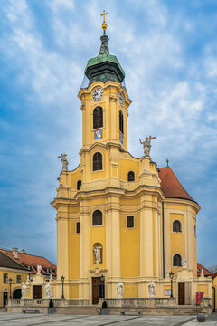Baroque church facade tower with clock and statues in Laxenburg