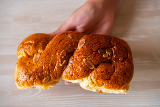 Almond bun bread roll pastry sweet dessert filling hand holding from Greek bakery on Ikaria island, Greece macro closeup