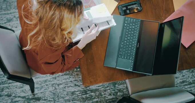 Overhead View of Woman Working at Desk with Laptop and Documents