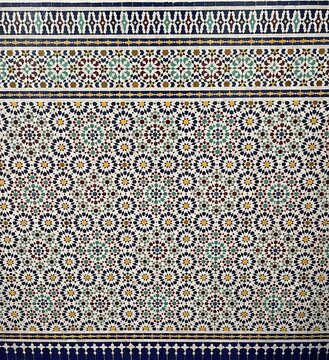 Traditional Moroccan zellige tile mosaic with colorful geometric and star patterns in Islamic architecture, Morocco. Editorial use only.
