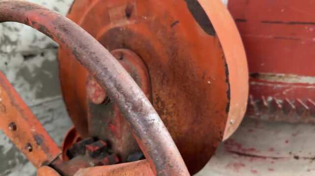 Rusted orange gearwork dominates the frame. Weathered metal shows signs of heavy use. Surface texture suggests frequent mechanical strain. Industrial relic speaks of past operations