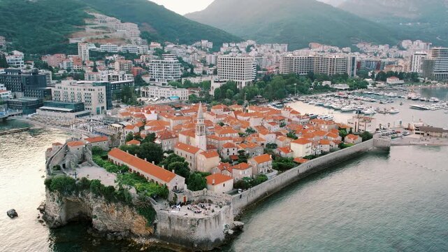 Dramatic drone footage highlighting fortress defenses amidst modern harbor and picturesque coastline