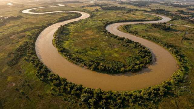Golden River Meanders Aerial View Over Emerald Green Plains